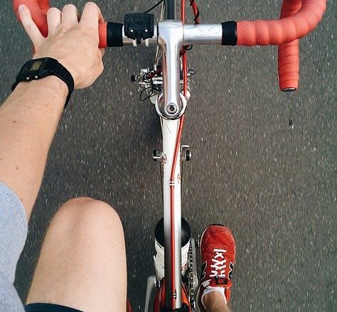 a hand reaches towards the handle bars of a bike