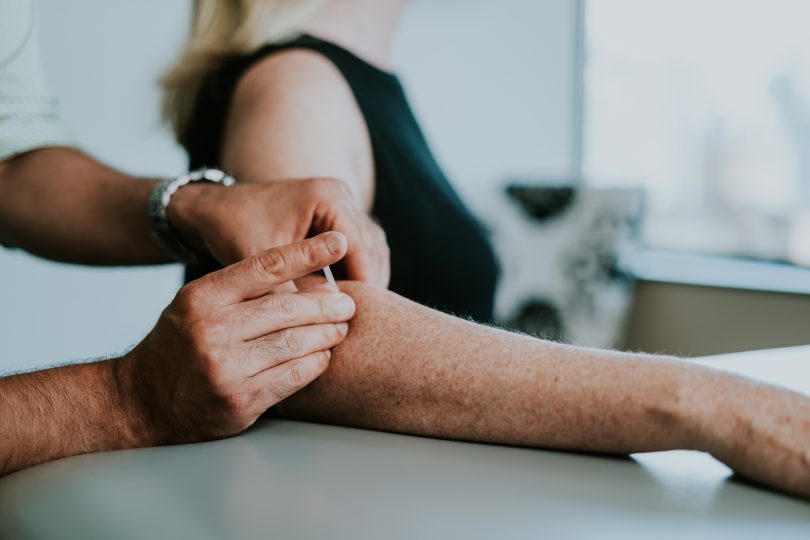 A physio is seen providing IMS to client in a physio clinic